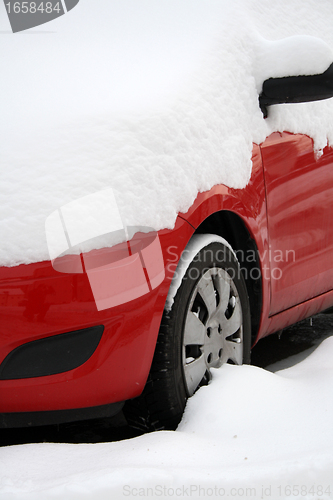 Image of red car covered with snow in winter 
