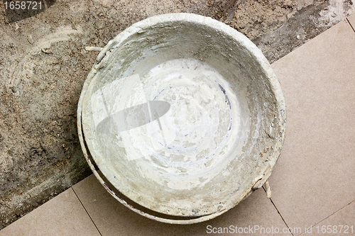Image of Grungy bucket on unfinished flooring