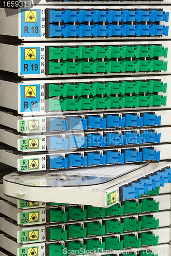 Image of fiber optic rack with high density of blue and green SC connectors