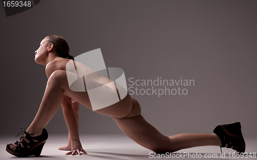 Image of picture of healthy naked woman, kneeling looking to light