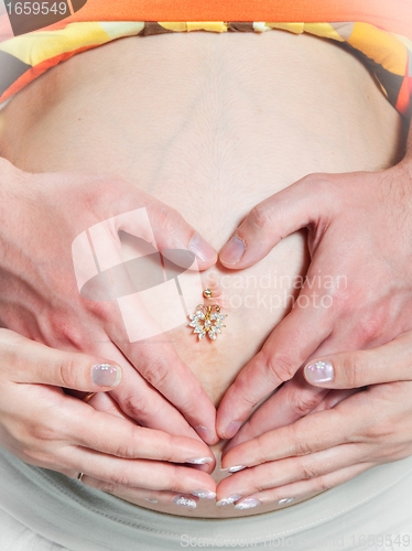 Image of pregnant woman tummy with husband hands