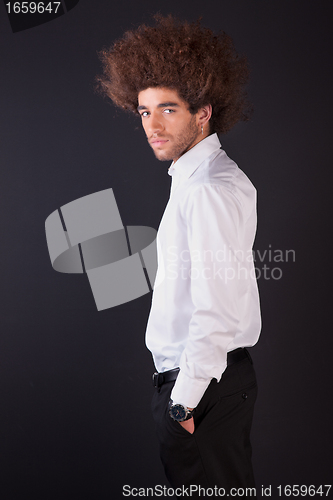 Image of Portrait of a handsome and young  business man isolated on black background