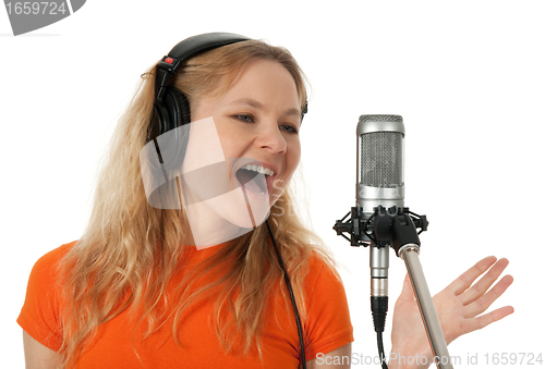 Image of Singer in headphones singing with the microphone