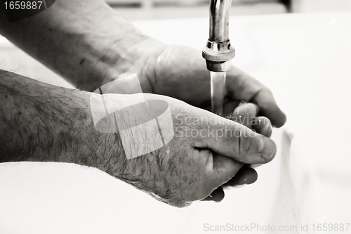 Image of Hands washing in basin