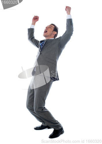 Image of Successful businessman celebrating with arms up