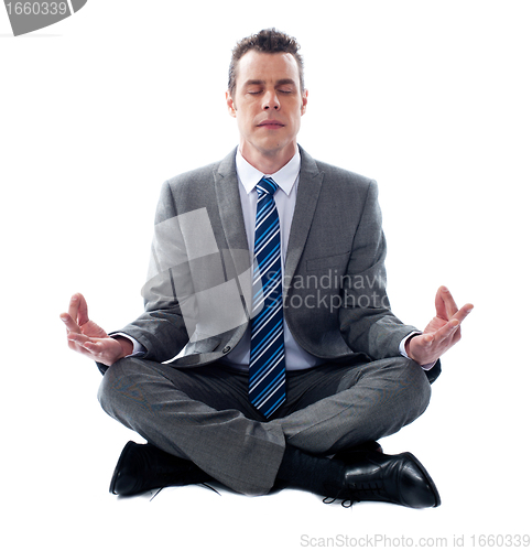Image of Businessman meditating in lotus position