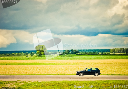 Image of Field and car on a road