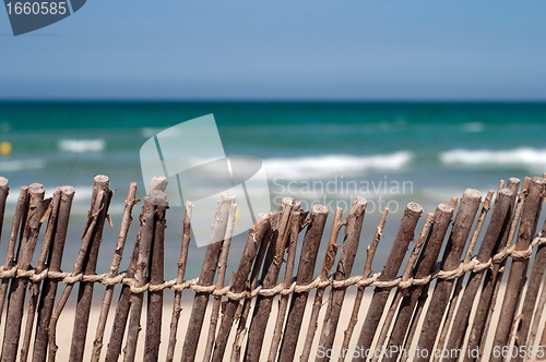 Image of Beach: blue sea, sand and fence