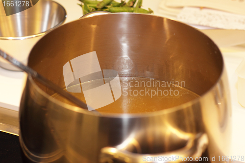 Image of aluminum pot with vegetable broth in a kitchen