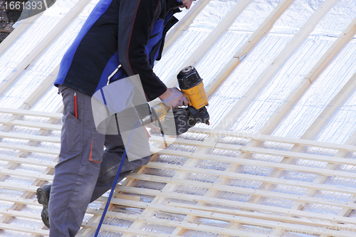 Image of roofer working on a new roof in wood