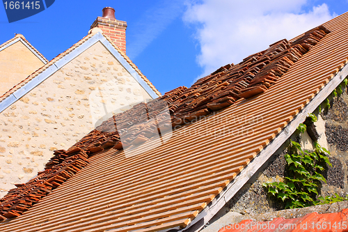 Image of renovation of a tiled roof of an old house