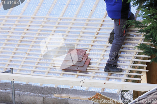 Image of roofer working on a new roof in wood