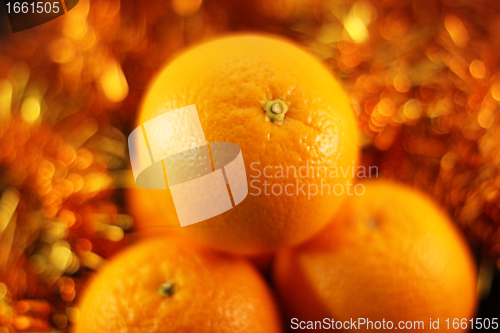 Image of orange close up on a background of twinkling garlands