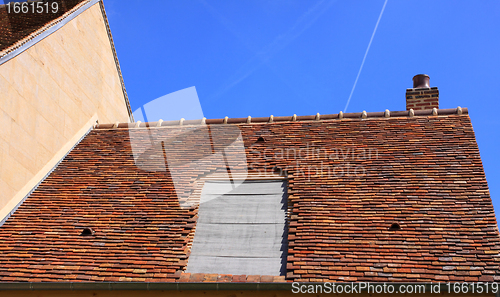 Image of renovation of a tiled roof of an old house