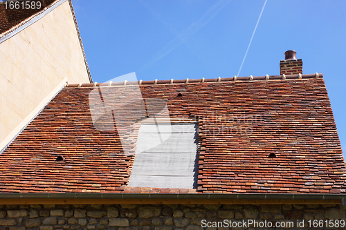 Image of renovation of a tiled roof of an old house