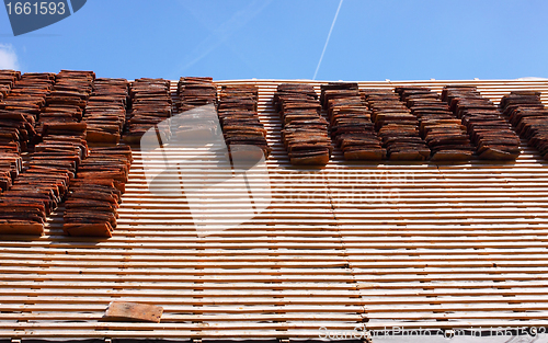 Image of renovation of a tiled roof of an old house