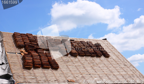 Image of renovation of a tiled roof of an old house