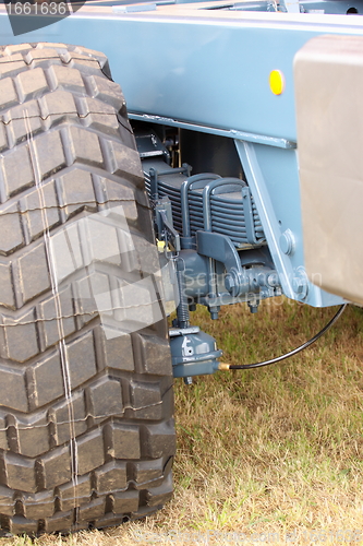 Image of shock absorber and tire of a large farm trailer