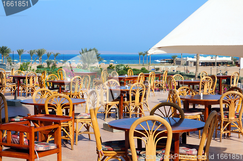 Image of tables in cafe on terrace near sea