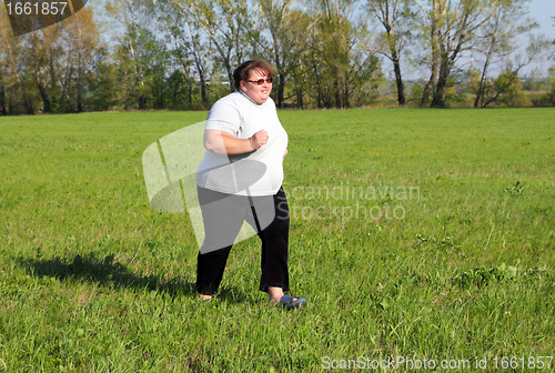 Image of  overweight woman running on meadow