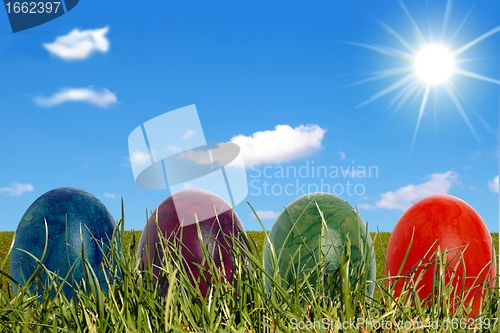 Image of Four easter eggs with sun and clouds