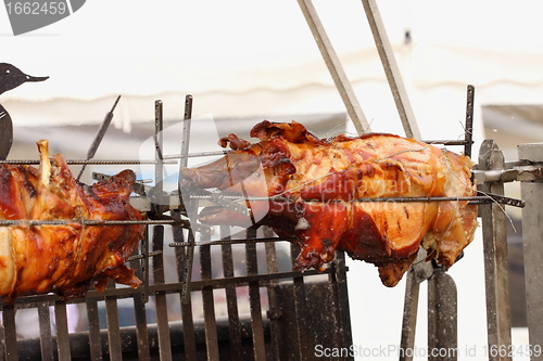 Image of pig on a spit. Spit roasting is a traditional international method of cooking a whole pig. 