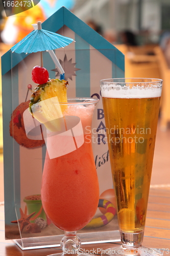 Image of glass of fruit cocktail and a glass of beer