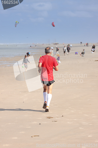 Image of man running on the beach sunny summer