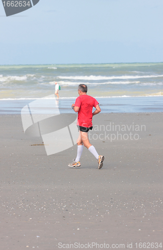 Image of man running on the beach sunny summer