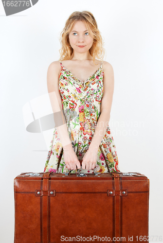 Image of Girl with vintage suitcase anticipating travel