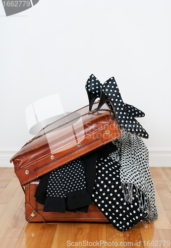 Image of Polka dot clothing in a vintage leather suitcase