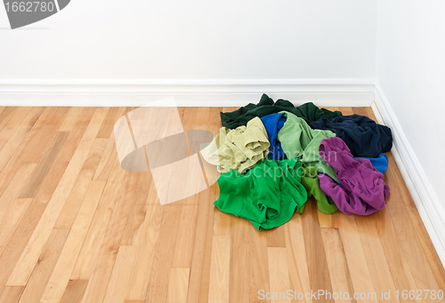 Image of Pile of bright clothes in the room corner