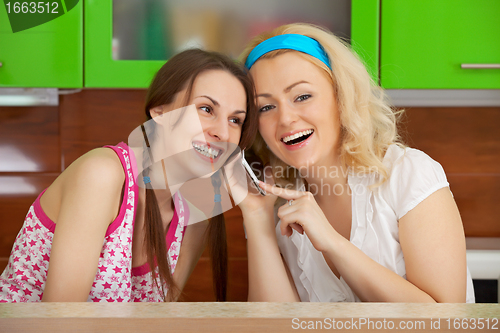 Image of Two friends on kitchen get a phone call
