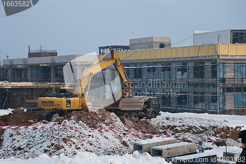 Image of Tipper and Excavating Machine at a Construction Site in Winter
