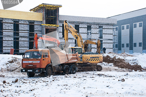 Image of Dump Truck and Excavators at the Construction Site in Winter