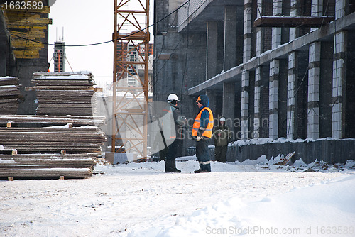 Image of Two Builders at the Construction Site in Winter Between Multi Storey Buildings Under Construction