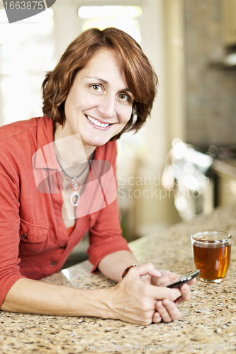 Image of Woman using cell phone at home