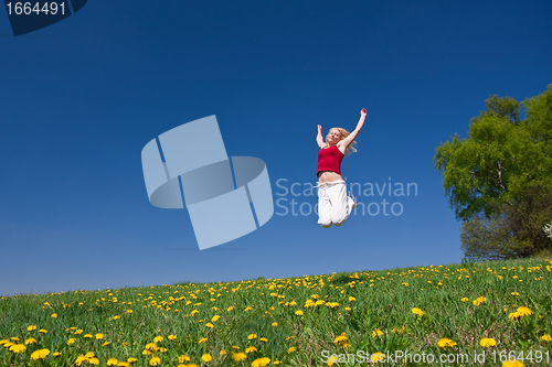 Image of young woman in red outfit having fun on meadow