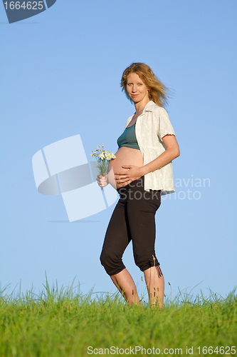 Image of pregnant woman on meadow