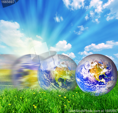 Image of Earth globe rolling on green grass