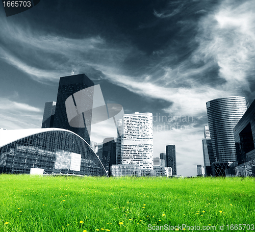 Image of Big city and green fresh meadow