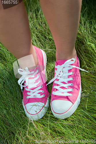 Image of Pink sneakers on girl legs on grass