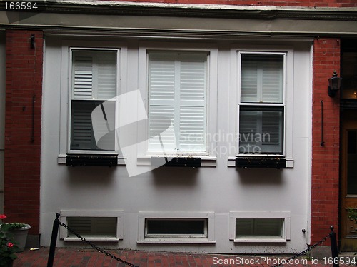 Image of three white windows in a red brick building