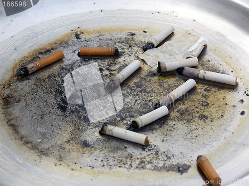 Image of Cigarette butts in dirty metal ashtray