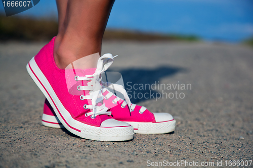 Image of Pink sneakers on girl, woman legs