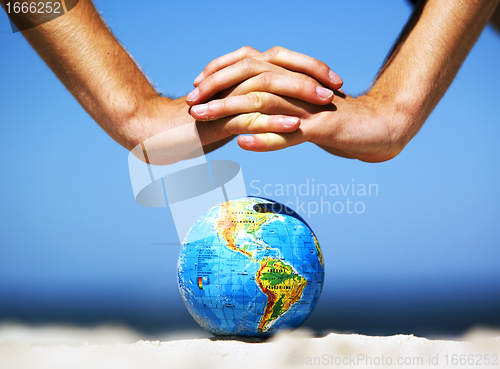 Image of Earth globe with hands over it. Conceptual image