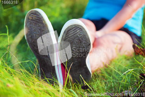 Image of Pink sneakers on girl legs on grass