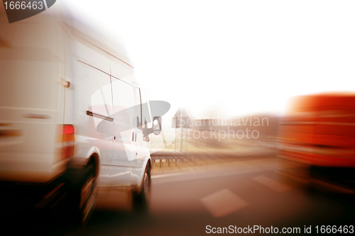 Image of Trucks, delivery vans on freeway