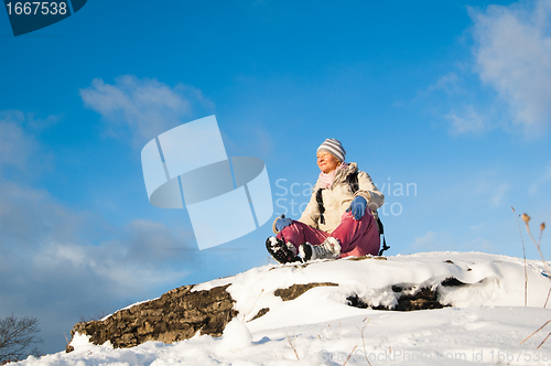 Image of woman sitting outdoors and enjoy the Sun