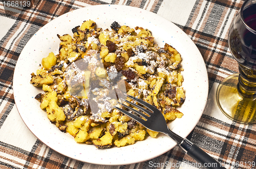 Image of  cut-up and sugared pancake with raisins